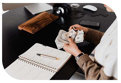Person writing in a notebook at a desk.